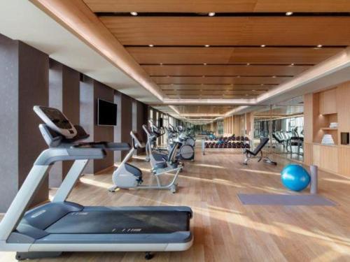 a gym with treadmills and elliptical machines at Shama Daqing Heilongjiang in Daqing