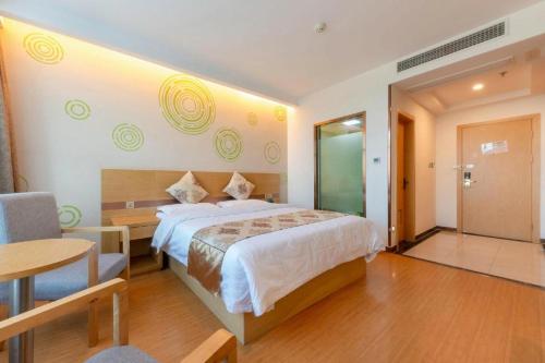 a bedroom with a bed and a table and a chair at GreenTree Inn Nantong University Industrial Expo City Express Hotel in Nantong