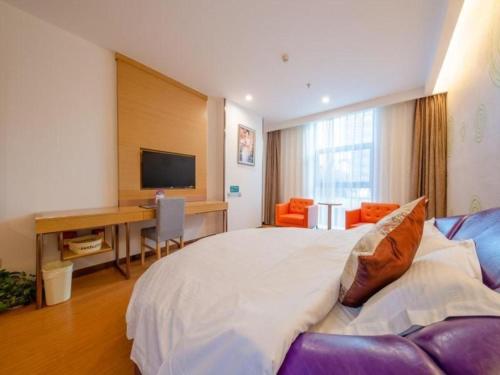 a bedroom with a large white bed and a desk at GreenTree Inn Nantong University Industrial Expo City Express Hotel in Nantong
