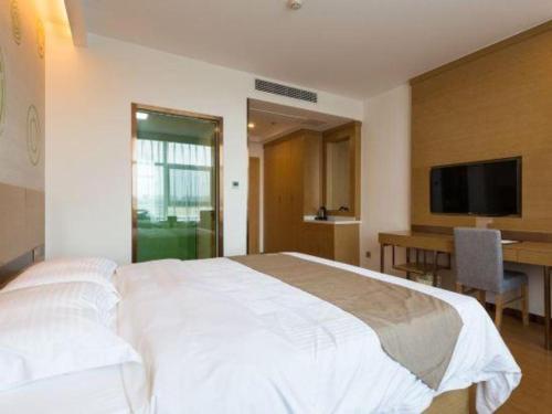 a bedroom with a large white bed and a desk at GreenTree Inn Nantong University Industrial Expo City Express Hotel in Nantong