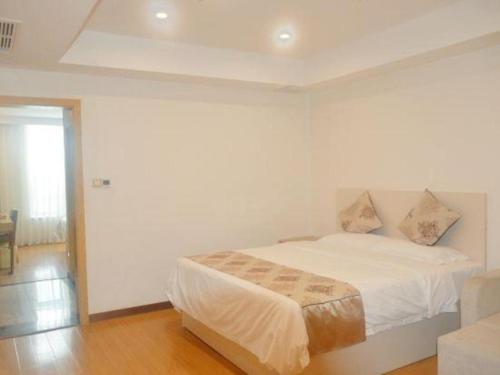 a white bedroom with a bed in a room at GreenTree Inn Nantong University Industrial Expo City Express Hotel in Nantong