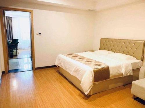a bedroom with a bed and a sliding glass door at GreenTree Inn Nantong University Industrial Expo City Express Hotel in Nantong