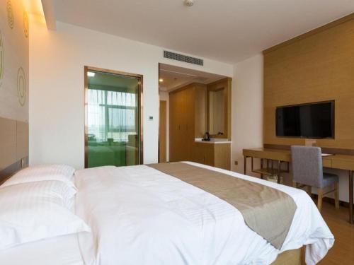 a bedroom with a large white bed and a desk at GreenTree Inn Nantong University Industrial Expo City Express Hotel in Nantong
