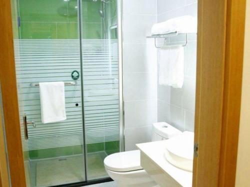 a bathroom with a toilet and a glass shower at GreenTree Inn Ordos Kangbashi District Ulan Mulun Street Branch in Ordos
