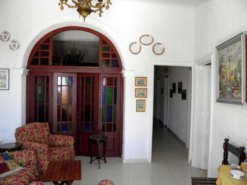 a living room with a red door with stained glass at Akis Apartments Kontogialos-Pelekas in Pelekas