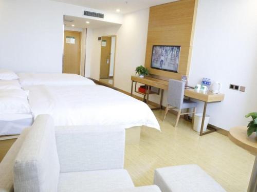 a hotel room with a bed and a desk at GreenTree Inn Ordos Kangbashi District Ulan Mulun Street Branch in Ordos