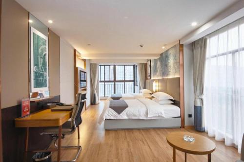 HexiaにあるGreenTree Eastern Hotel Huai'an Bus Station Zhou Enlai Memorialのベッドルーム1室(大型ベッド1台、デスク、デスク付)