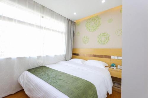 a bedroom with a large bed and a window at GreenTree Inn Jiaxin Puyuan Kaixuan Road in Jiaxing