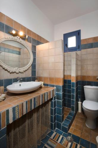 a bathroom with a sink and a toilet and a mirror at Villa Elias in Archangelos