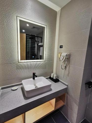 a bathroom with a sink and a mirror at GreenTree Inn Ganzhou Gan County Bus Station in Ganzhou