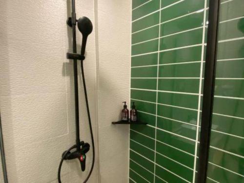 a shower with a black shower head in a bathroom at GreenTree Inn Ganzhou Gan County Bus Station in Ganzhou