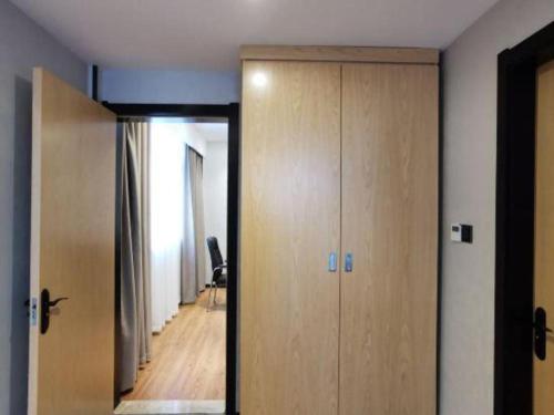 a room with a door and a hallway with a chair at GreenTree Inn Ganzhou Gan County Bus Station in Ganzhou