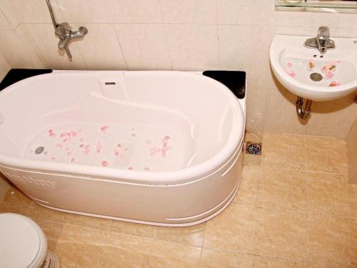 y baño con bañera junto a un lavabo. en Kangaroo Hostel, en Hanói