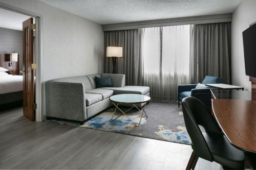 a living room with a couch and a room with a bed at West Des Moines Marriott in West Des Moines