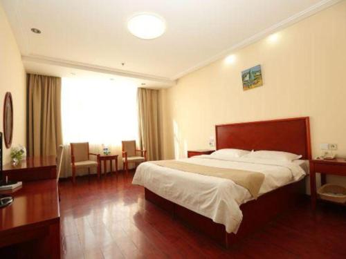 a bedroom with a large bed and a large window at GreenTree Inn Tianjin Wuqing Distric Bohai Market in Tianjin