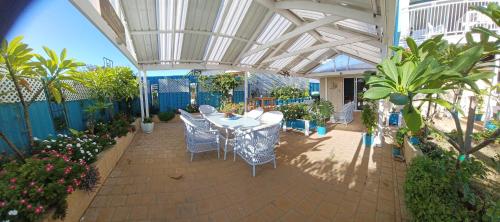 a patio with a table and chairs and plants at Palm Beach Guest House in Rockingham