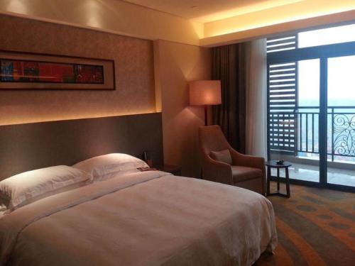 a hotel room with a bed and a chair and a window at Wuhan Gleetour Hotel in Wuhan