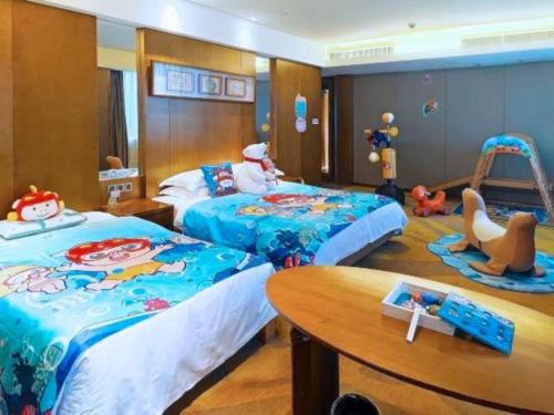 a childrens bedroom with two beds and a table at Wuhan Gleetour Hotel in Wuhan