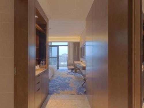 a hallway with a bathroom with a sink and a desk at Wuhan Gleetour Hotel in Wuhan