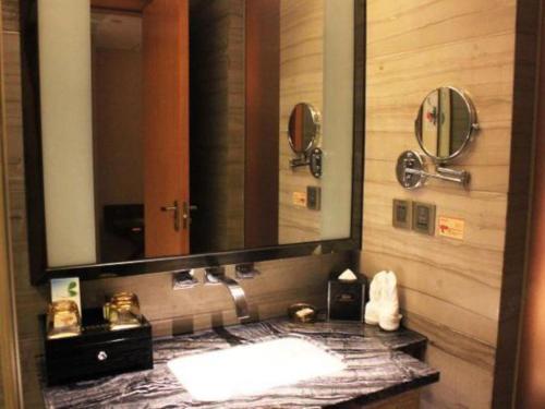 a bathroom with a sink and a large mirror at Zhangjiagang Zhonglian GDH International Hotel in Zhangjiagang