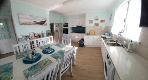 a kitchen with a table and chairs and a sink at Palm Beach Guest House in Rockingham