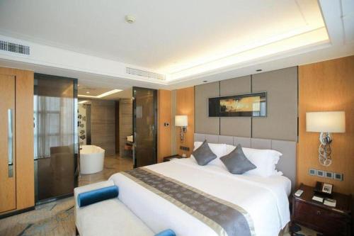 a large bedroom with a large bed and a couch at Zhangjiagang Zhonglian GDH International Hotel in Zhangjiagang