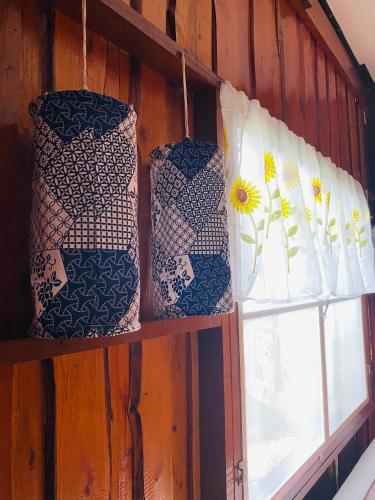 three ties sitting on a shelf next to a window at Banthai Guesthouse in Phetchaburi