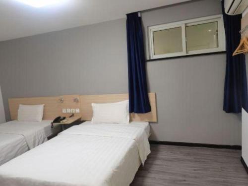 a room with two beds and a window at 7 Days Inn Tianjin Binhai New District Yujiabao Metro Station in Binhai