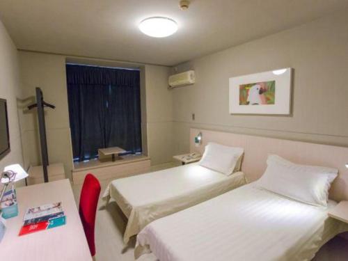 a hotel room with two beds and a window at Jinjiang Inn Tiayuan Wuyi Square in Taiyuan