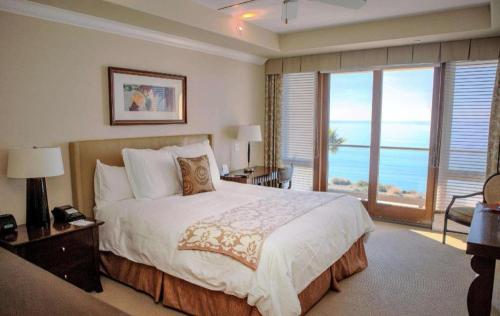 a bedroom with a bed with a view of the ocean at Dolphin Bay Resort and Spa in Pismo Beach
