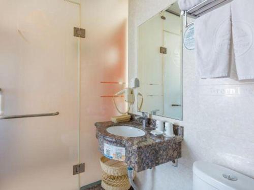 a bathroom with a sink and a mirror at GreenTree Inn Langfang GuanGYAng District GuanGYAng Road City Government Express Hotel in Langfang