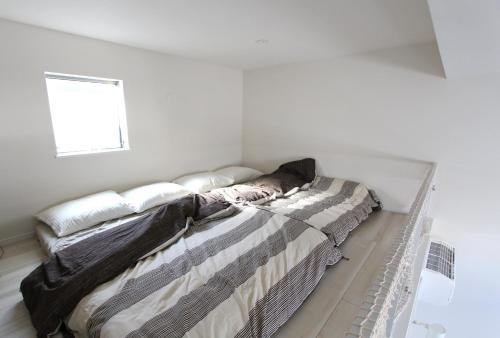 a bed in a white room with a window at Shibuya Stay Tokyo A202 in Tokyo