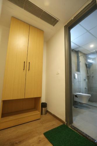a bathroom with a large wooden cabinet and a sink at Hotel Grand Arcasia in Ghaziabad