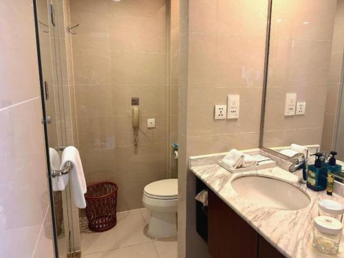 a bathroom with a sink and a toilet and a shower at Jinjiang Metropolo Shanghai Minhang in Shanghai