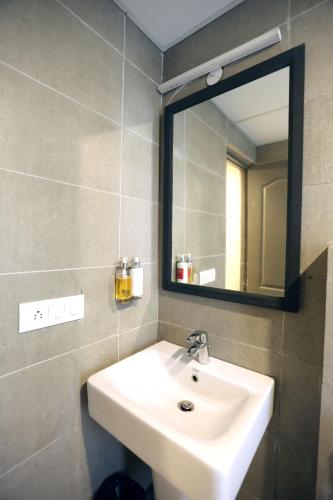 a bathroom with a sink and a mirror at Hotel Grand Arcasia in Ghaziabad