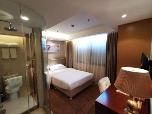 a hotel room with a bed and a bathroom at Jinjiang Metropolo Shanghai Minhang in Shanghai