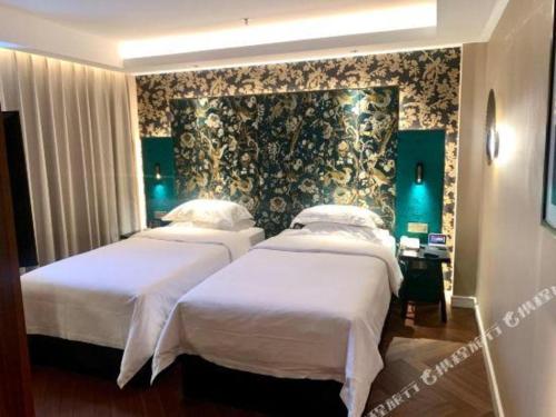 a hotel room with two beds and a wall at Jinjiang Metropolo Shanghai Minhang in Shanghai