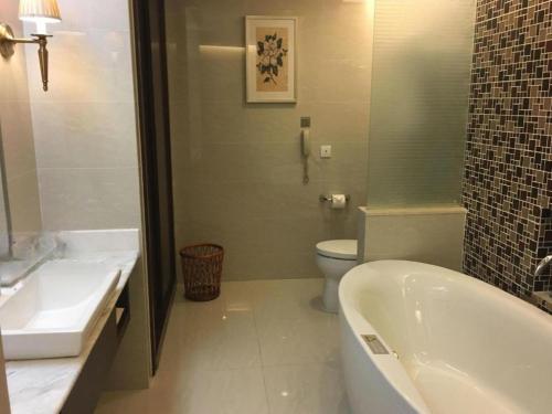 a bathroom with a tub and a toilet and a sink at Jinjiang Metropolo Shanghai Minhang in Shanghai