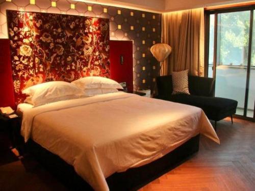 a bedroom with a large white bed and a chair at Jinjiang Metropolo Shanghai Minhang in Shanghai