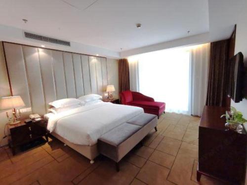 a bedroom with a large bed and a red chair at Jinjiang Metropolo Shanghai Minhang in Shanghai