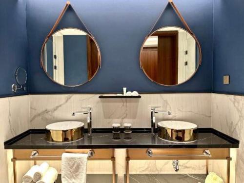 a bathroom with two sinks and two mirrors at Jinjiang Metropolo Shanghai Minhang in Shanghai