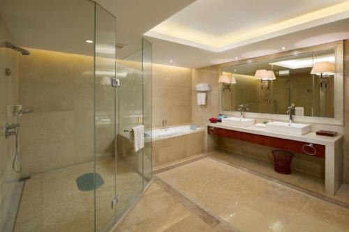 a large bathroom with two sinks and a shower at Yiyang Huatian Hotel in Yiyang