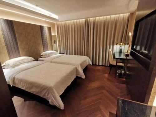 a hotel room with two beds and a desk at Jinjiang Metropolo Shanghai Minhang in Shanghai