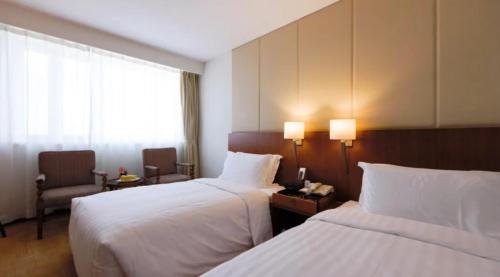 a hotel room with two beds and a window at Jianguo Garden Hotel in Beijing