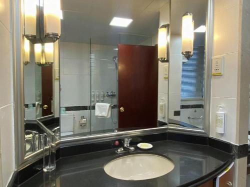a bathroom with a sink and a large mirror at Jianguo Garden Hotel in Beijing