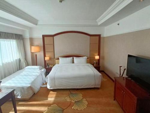 a hotel room with two beds and a flat screen tv at Jianguo Garden Hotel in Beijing