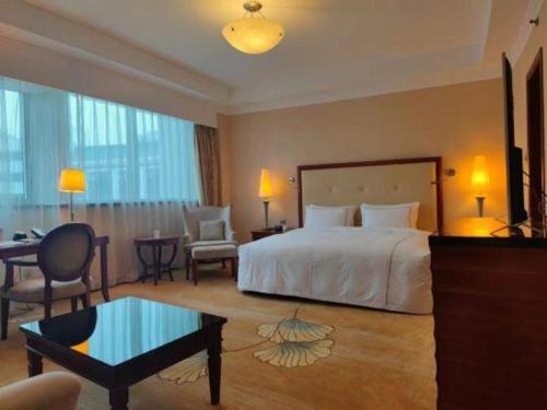 a hotel room with a bed and a table and chairs at Jianguo Garden Hotel in Beijing