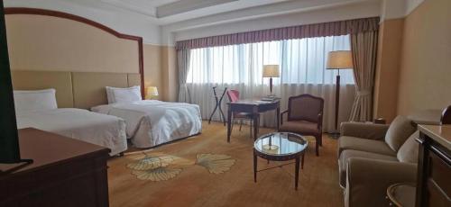 a hotel room with a bedroom with a bed and a couch at Jianguo Garden Hotel in Beijing