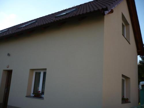 a white building with two windows and a roof at Rivendell Apartments in Prague