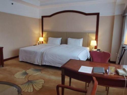 a hotel room with a bed and a desk and a desk at Jianguo Garden Hotel in Beijing